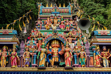 Muchos dioses hindúes esculpidos en piedra en el arco de acceso a la escalera del festival Tapuisam en las cuevas de Batu (Gombak, Kuala Lumpur, Malasia) / Gua Batu