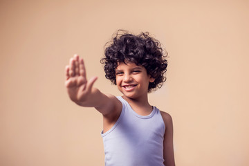 A portrait of angry kid boy showing stop gesture. Children and emotions concept