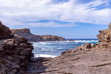 Beautiful view of a rocky bay with waves on the sea on the island of Menorca, Balearic islands, Spain