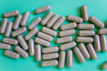 top view capsules of dietary supplements on green background. Layout white soft soluble. copy space. Concept of healthy life, vitamin.