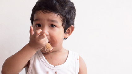 Little boy eating ice cream at home kid has dirty mouth with chocolate summer time concept. 