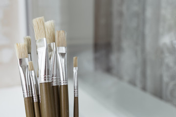 Brushes for painting on the white windowsill. A process of painting. Hobby. 