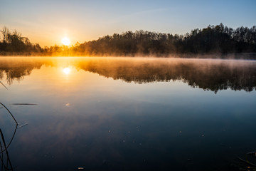 sunrise over the lake with tree reflection and beautiful fog