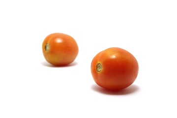 Two tomatoes (Solanum lycopersicum) isolated on white background