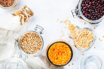 Zero waste and sustanable lifestyle. Plastic free storage and cooking concept. Various organic superfoods, beans, grains, cereals, legumes, seeds in reusable cans and jars. Copy space top view. 