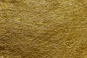 Golden crumpled shining foil texture