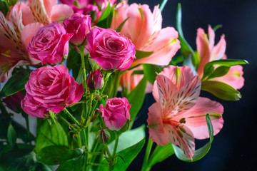 Beautiful bouquet of fresh flowers close-up on a dark background.