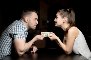 A man and a woman pull money at each other, comically angry