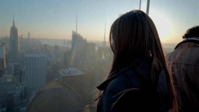 Close-up of woman looking Empire State Building while standing observation point during sunset - New York City, New York