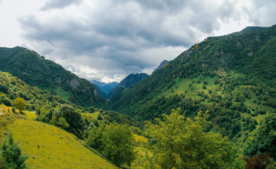 Paisaje natural de Cette-Eygun, un pequeño pueblo en el lado norte de los Pirineos franceses. Hermosas laderas verdes a finales de la primavera en un día nublado. Francia.