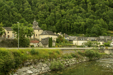 Fototapeta na wymiar Sarrance (pequeño pueblo en los Pirineos franceses) con la Iglesia de Nuestra Señora de la Piedra (en francés: Église Notre Dame de la Pierre) y el río Aspe.