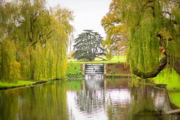 Obraz premium Small lake in a park with a waterfall