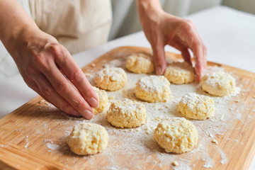 Woman making homemade cheese pancake for breakfast. Girls hands in flour. Cooking fresh healthy food. Preparation raw ingredients for baking. Chef kneading on kitchen table. Culinary work