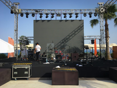Open air show stage set up with led screen, sound and light system. Back line with drums.