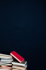 many stacks of educational books for college exams in the library on a black background