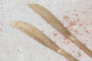 Obraz premium Two old bronze knives on concrete background.