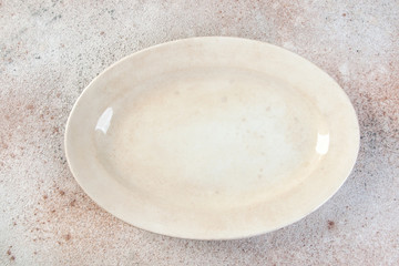 Antique porcelain oval plate on concrete