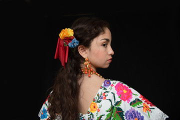 adolecente latina mexicanana, bailarina con traje tipico de yucatan mexico, con fondo negro, modelo de traje bordado con flores en punto de cruz hecho a mano, con cadenas de oro y cuentas de coral