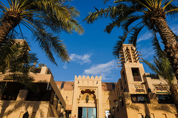 Modern Arabic-style buildings in the UAE Dubai . View of the building with palm trees from below