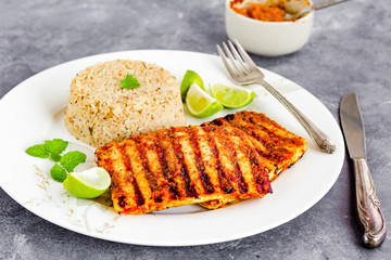 Grilled Paneer Steaks with Herbed Rice and Piri Piri Sauce, Garnished with Lemon, Cilantro and Mingt Leaves, Close Up Photo
