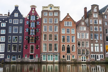 Obraz premium Famous dancing houses and buildings in Amsterdam with reflection in canal water.