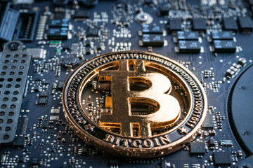 Cryptocurrency background. Gold Bitcoin Computer electronic circuit board motherboard. CryptoCash...