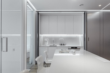 white kitchen, cozy kitchen in the morning to have coffee and read a magazine. plastic chairs. compact kitchen minimalism