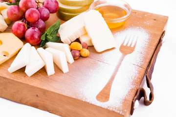 Cheese platter on a wooden board on a white background