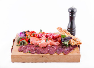 Assorted meat on a wooden board on a white background. Horizontal photo