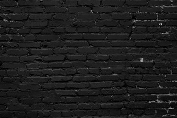 Abstract black background. Black paint on a brick wall. The texture of the black brick wall. The wall of the black house.