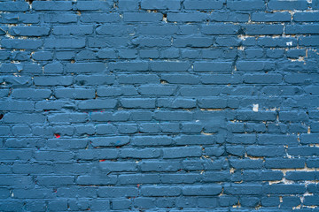 Abstract blue background. Blue paint on a brick wall. Texture of a blue brick wall. The wall of the blue house.