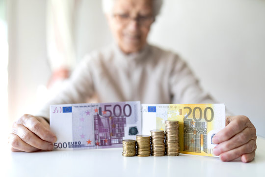 older woman with white hair and money on her hands