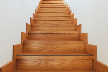 Wooden staircase and white walls bottom view
