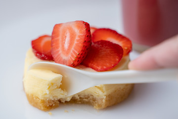 Spoon Takes a Piece of Delicious Strawberry Cheesecake