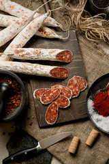 Beef jarky sausage with spices on wooden board with garlic pepper jar wooden texture top