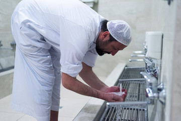 Muslim man taking ablution for prayer. Islamic Religious Rite Ceremony Of Ablution. Young Muslim...