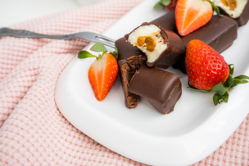 Curd cheese in chocolate. Sweet cottage cheese in chocolate with strawberries.