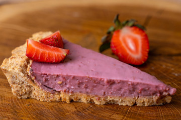 Close-up view of fresh strawberries with slice of strawberry cheesecake.