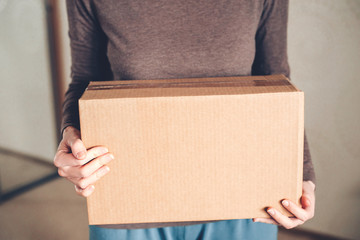 Women's hands hold the box with the delivered order. The concept of delivery.