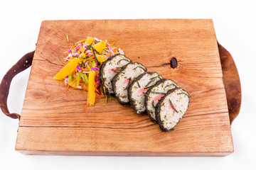 Oriental style pike perch with salmon and..celery and citrus julienne on a wooden board