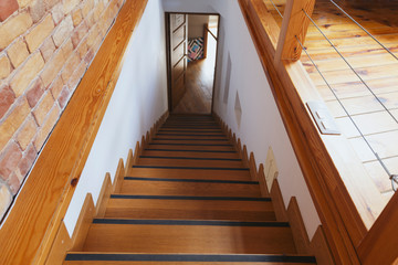 Wooden staircase in coworking space with wall