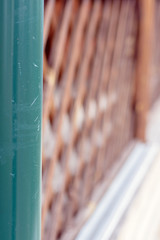 A fragment of a drainpipe on the background of a wooden railing of the verandah