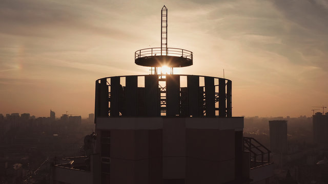 silhouette of a roof spire, lightning rod in a skyscraper. against the backdrop of sunset and evening city center