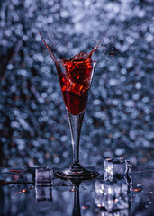 Chupito de licor rojo con hielo