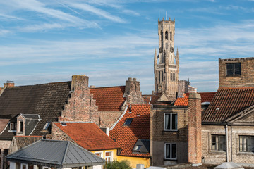 View of the old town of Bruges Belgium. 
Belfry tower protrudes above the typical tiled roofs.