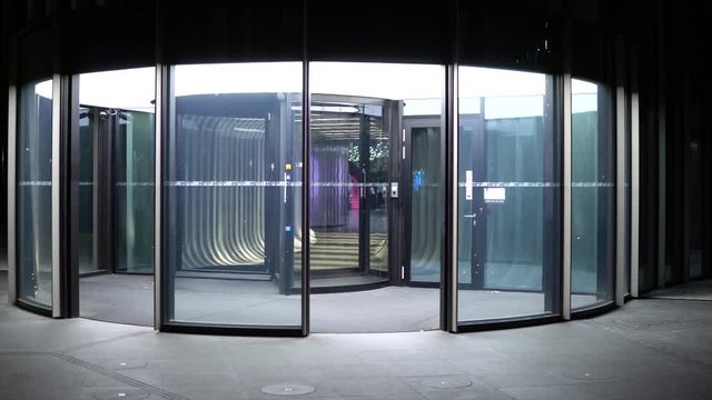 A revolving door to a building in an urban area at night - front view