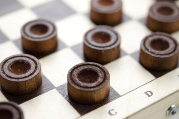 Party of wooden checkers close up. The strategy