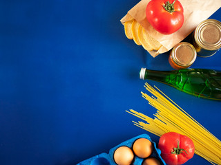 Food supplies on blue background, top view with copy space