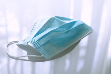 Disposable medical mask on light gray background