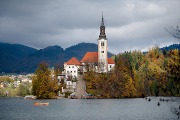 Travel Slovenia, Europe. Bled Lake with Island, Castle and Alps Mountain on background. Side view. Bled Lake one of most amazing tourist attractions. Autumn nature landscape.